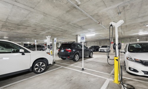 a parking garage with cars and ev charging